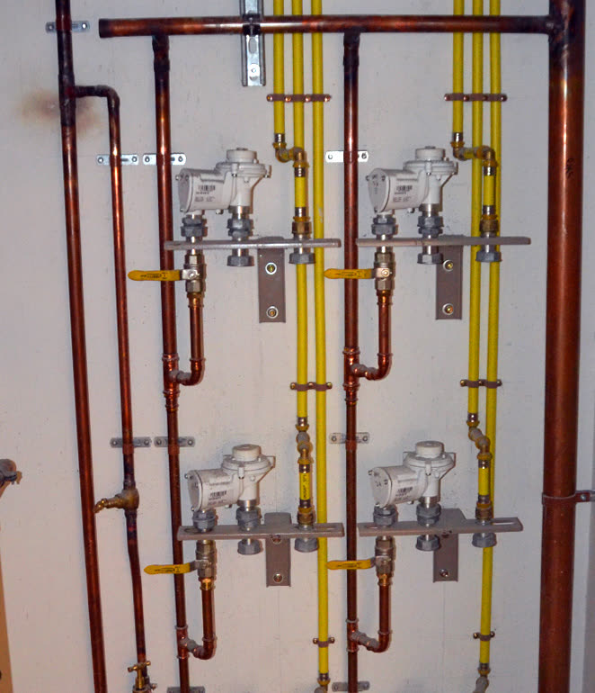 Commercial plumbing installation with copper pipes and gas lines